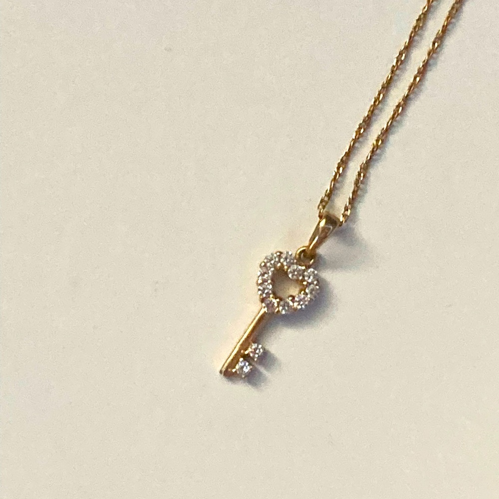 Gold shaped heart key necklace with diamonds.